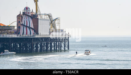 Brighton, UK. 19 Apr, 2019. Ein wasser Skifahrer Köpfe um Brighton Palace Pier als Besucher strömen zum Meer die Sonne zu genießen, da die Temperaturen Mitte der 20er Jahre entlang der Südküste: Simon Dack/Alamy Leben Nachrichten erreichen Stockfoto