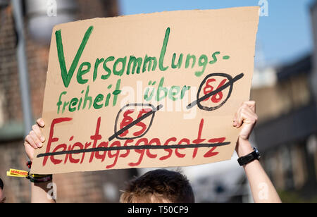 Hannover, Deutschland. 19 Apr, 2019. Die Teilnehmer der Demonstration gegen das Verbot der Tanz am Karfreitag stehen mit Fahnen. Tanz Demo gegen Tanz Verbot am Karfreitag, die Sitzung wurde von einem Mitglied der Grünen Jugend registriert. Die Polizei Hannover hat ein Verbot auf Flöten, Musikinstrumente und Lautsprecher, die vom Verwaltungsgericht Hannover in einem summarischen Verfahren bestätigt wurde. Credit: Peter Steffen/dpa/Alamy leben Nachrichten Stockfoto