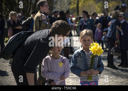 Warszawa, Mazowieckie, Polen. 19 Apr, 2019. Ein Kind gesehen Narzissen Holding als Symbol der Ghetto während der Zeremonie. Der 76. Jahrestag des Ausbruchs des Aufstands im Warschauer Ghetto direkt neben der POLIN Museum der Geschichte der Polnischen Juden, Vertreter des Europäischen Parlaments, staatlichen und lokalen Behörden, die jüdische Gemeinde und die Bewohner der Hauptstadt versammelten sich in Warschau zu feiern. Credit: ZUMA Press, Inc./Alamy leben Nachrichten Stockfoto