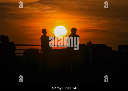 London. 19. Apr 2019. Wetter in Großbritannien: London, UK, 19. April 2019. Es sind zwei Personen gegen einen schönen Sonnenuntergang an der Themse an der Londoner South Bank. Nach einem Tag des blauen Himmel und ungewöhnlich warmen Temperaturen, den Rest der Ostern Wochenende dürfte ähnlich angenehmes Wetter zu sehen. Credit: Imageplotter/Alamy leben Nachrichten Stockfoto