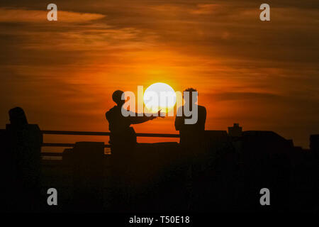 London. 19. Apr 2019. Wetter in Großbritannien: London, UK, 19. April 2019. Es sind zwei Personen gegen einen schönen Sonnenuntergang an der Themse an der Londoner South Bank. Nach einem Tag des blauen Himmel und ungewöhnlich warmen Temperaturen, den Rest der Ostern Wochenende dürfte ähnlich angenehmes Wetter zu sehen. Credit: Imageplotter/Alamy leben Nachrichten Stockfoto