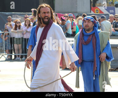 Jesus Auseinandersetzungen mit der Priester während einer Aufführung von "Die Passion Jesu" von der Wintershall Spieler auf dem Trafalgar Square. Rund 20.000 Menschen dem Londoner Trafalgar Square für die jährliche Leistung der Passion Jesu durch die winterhall Spieler. Die Wiederinkraftsetzung des Lebens Jesu von seiner Ankunft in Jerusalem zu seiner Kreuzigung und Auferstehung ist durch eine Form über 100 Akteure und Freiwillige für kostenlos jeden Karfreitag durchgeführt. Stockfoto