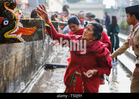 Kathmandu, Nepal. 19 Apr, 2019. Nepalesische devotees Splash heiligen Wasser während Baisdhara mela Full Moon Festival selber. Tausende von Gläubigen versammelten Heiligen Bad in 22 Wasserhosen Balaju für ihre spirituelle Reinigung und in der Überzeugung vieler Erkrankungen Behandlungen zu nehmen. Credit: Sunil Pradhan/SOPA Images/ZUMA Draht/Alamy leben Nachrichten Stockfoto