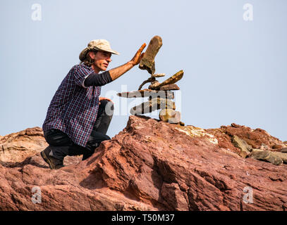 Dunbar, East Lothian, Schottland, Vereinigtes Königreich, 20. April 2019. Europäische Stein stacking Meisterschaft: Pedro Duran aus Spanien, Gesamtsieger des letzten Jahres Salden Steine am Auge Cave Beach Stockfoto