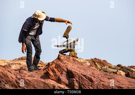 Dunbar, East Lothian, Schottland, Vereinigtes Königreich, 20. April 2019. Europäische Stein stacking Meisterschaft: Pedro Duran aus Spanien, Gesamtsieger des letzten Jahres Salden Steine am Auge Cave Beach Stockfoto