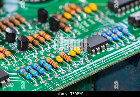 Elektronische Komponenten. Integrierte Schaltkreise, Widerstände, Transistoren und Kondensatoren auf der FBG. Grün Kupfer board Detail. Standard Farbe Code. Abfallsortierung. Stockfoto