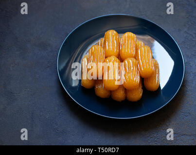 Traditionelle Dessert tulumba genannt. Türkische Küche. Balkan Küche. Levantinischen Küche. Auf einem blauen Hintergrund, serviert auf einem blauen Platte Stockfoto