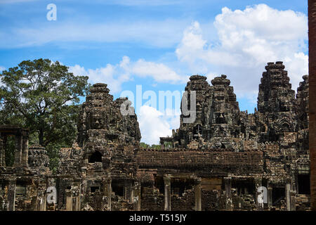 Gesichter geschnitzt in die Türme an der Bayon, der Tempel von Gesichtern, an einem Sommertag in Angkor Thom, Angkor Archäologischer Park, Kambodscha. Stockfoto