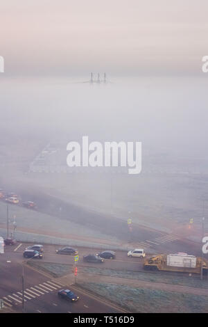 Morgennebel deckt die Fabrik und electrotowers. Ungewöhnliche Landschaft. Autos im Nebel Stockfoto