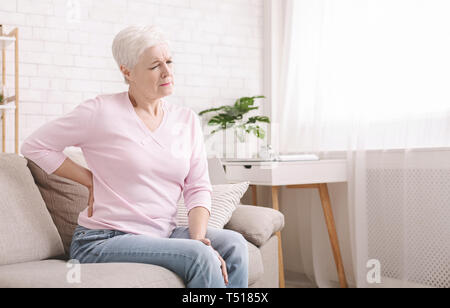 Ältere Frau leiden unter Rückenschmerzen zu Hause Stockfoto