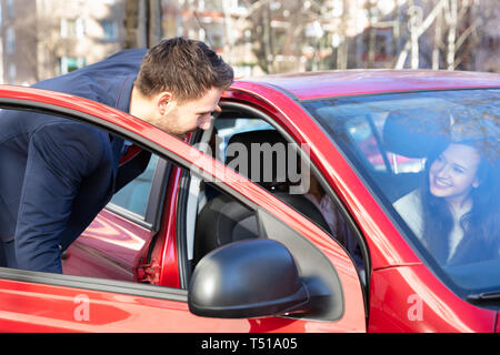 Lächelnden jungen Mann mit einer Dame im Auto Stockfoto