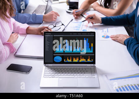 Nahaufnahme der Männlichen und Weiblichen Geschäftsleute in Sitzung Graphen diskutieren Stockfoto