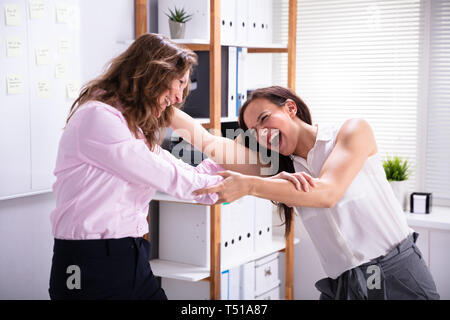 Zwei Business Frau kämpfen mit jeder anderen im Büro Stockfoto