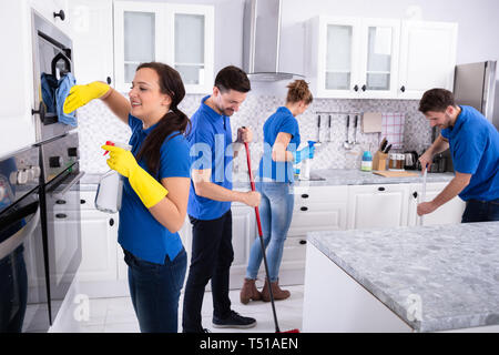 Gruppe von Jungen Hausmeister in Uniform Reinigung Küche zu Hause Stockfoto