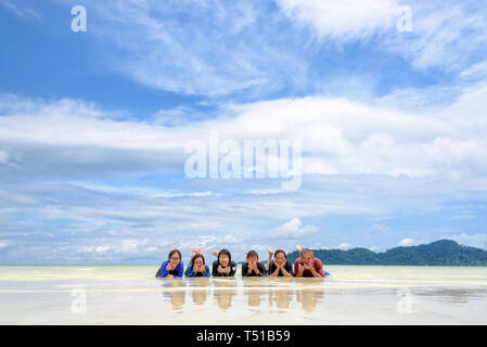 Asiatische Gruppe für Erwachsene und Teens sind Familie, glückliches Leben genießen, indem sie zusammen am Strand liegen auf blauer Himmel, Urlaub im Sommer Urlaub im K Stockfoto