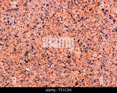 Roter Granit mit schwarzen Flecken Hintergrund. Textur, Muster. Stockfoto