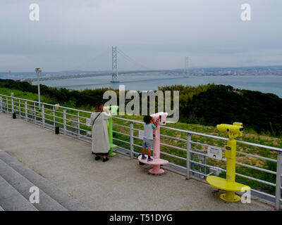 Awaji, Hyogo, Japan - 17. September 2018: Blick auf die akashi Kaikyō Brücke und einige Toursit durch das Fernglas aus der Awaji Service Ar suchen Stockfoto