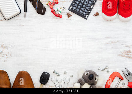 Der Vater Outfit und Werkzeuge Zubehör und Sohn Schuhe und Spielzeug Schuhe auf weiße Holz Hintergrund. Konzept der Familie, alleinerziehende Mutter und Vater da Stockfoto