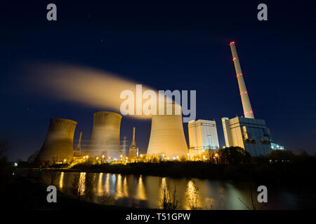 Ein Kohlekraftwerk mit drei Kühltürme bei Nacht. Stockfoto