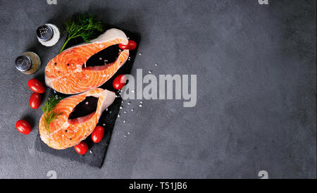 Frisch zwei roher Lachs Steaks auf dunklem Hintergrund Stockfoto