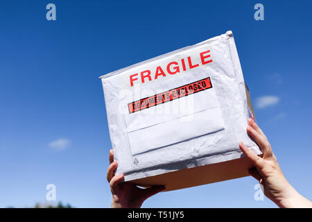 Fragile Paket vor blauem Himmel. Stockfoto