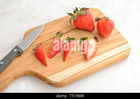 Schneiden Erdbeeren auf einem Schneidebrett Stockfoto