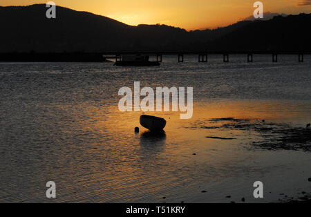 Eine wunderschön romantische Szene eines alten Rohöl Fischerboot im Sonnenuntergang Wasser der Knysna Einlass in Südafrika wider. Stockfoto