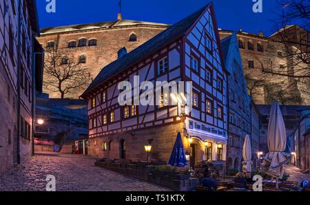 Beleuchteten Kaiserburg, historische Fachwerkhaus vor, Dämmerung, Nürnberg, Mittelfranken, Bayern, Deutschland Stockfoto