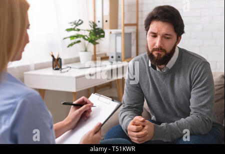 Einsamer Mann seine Probleme erkennen, erhalten psychologische Hilfe von professionellen Psychotherapeuten, leeren Raum Stockfoto