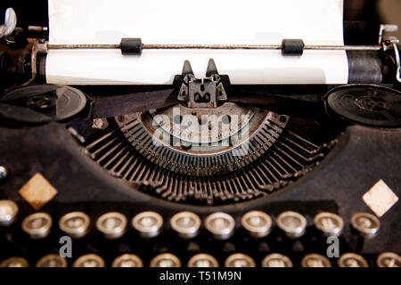 Close-up alte antike Schreibmaschine auf dem Tisch des Schriftstellers mit Papier. Stockfoto