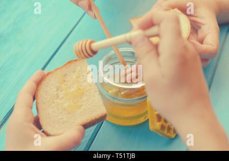 Honig Honig und Zubehör für den Einsatz auf einem blauen Hintergrund aus Holz Stockfoto