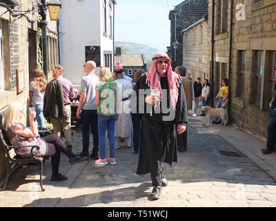 Während Zuschauer vor den Dorfpubs durch die Straßen schlendern, macht sich einer der Künstler des Karfreitags-Heptonstall-Pace Egg Play auf den Weg zum Weavers Square Stockfoto