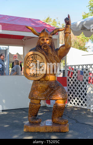 Hand geschnitzten Viking Statue, mit Schild, Helm und Hand hoch gehalten. Stockfoto