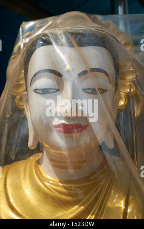 Eine fertige Buddha Skulptur in Plastik eingewickelt ist und zum Verkauf bereit. In Mandalay, Myanmar. Stockfoto