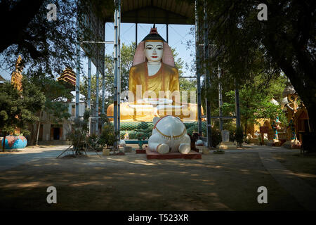 Ein weißer Elefant Skulptur, kniete nieder und betete vor einem großen sitzenden Buddha Kyaw Aung San Dar Kloster in der Nähe von Mandalay, Myanmar. Stockfoto