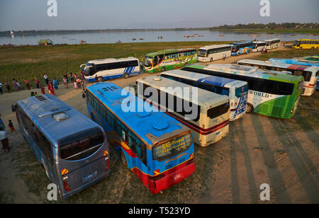 Touristenbusse Park an der Westseite des U-Bein Brücke in der Nähe von Mandalay, Myanmar. Bei Sonnenuntergang, die Attraktion ist mit Reisegruppen überwältigt. Stockfoto