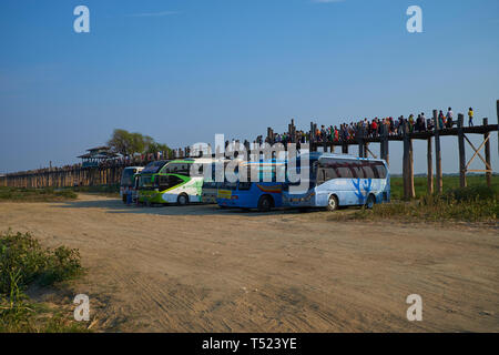 Touristenbusse Park an der Westseite des U-Bein Brücke in der Nähe von Mandalay, Myanmar. Bei Sonnenuntergang, die Attraktion ist mit Reisegruppen überwältigt. Stockfoto