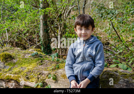 Ein Junge wirft für ein Portrait außerhalb in einem bewaldeten Landschaft, Stockfoto