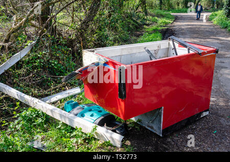 Eine helle rote kommerzielle Gefrierschrank ist mit anderen Müll auf einem Feldweg in der Nähe des Dorfes Perton, Wolverhampton in South Staffordshire entleert. Stockfoto