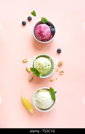 Eis Sortiment. Verschiedene Früchte und Beeren Eis auf rosa Hintergrund, kopieren. Gefrorener Joghurt oder Eis - gesunde Sommer Nachtisch. Stockfoto