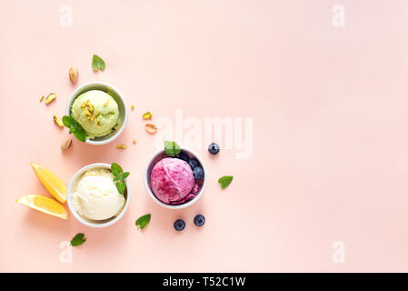 Eis Sortiment. Verschiedene Früchte und Beeren Eis auf rosa Hintergrund, kopieren. Gefrorener Joghurt oder Eis - gesunde Sommer Nachtisch. Stockfoto