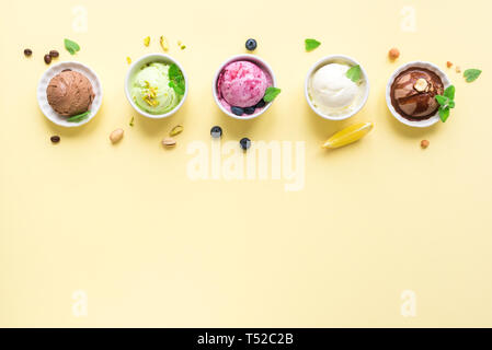 Eis Sortiment. Verschiedene Früchte und Beeren Eis auf gelbem Hintergrund, kopieren. Gefrorener Joghurt oder Eis - gesunde Sommer Nachtisch. Stockfoto