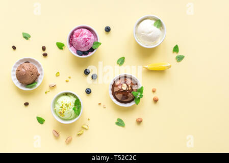 Eis Sortiment. Verschiedene Früchte und Beeren Eis auf gelbem Hintergrund, kopieren. Gefrorener Joghurt oder Eis - gesunde Sommer Nachtisch. Stockfoto