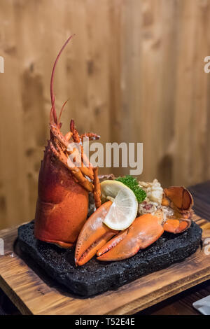 Gegrillter Hummer mit Zitrone auf dem Teller serviert. Stockfoto