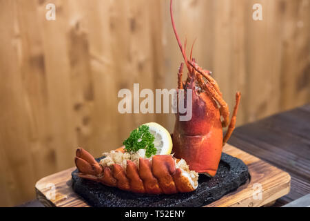 Gegrillter Hummer mit Zitrone auf dem Teller serviert. Stockfoto