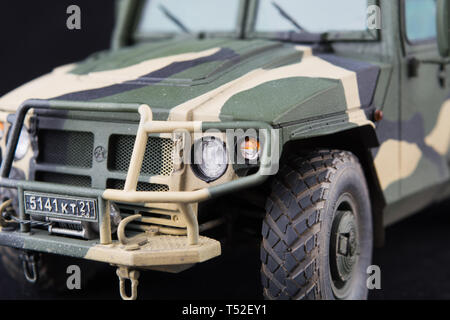 Russische Militärs gepanzerten Camouflage jeep Tiger. Detailansicht. Kunststoff Modell auf dunklem Hintergrund. Vorderansicht mit Scheinwerfer und zum Stoßfänger Stockfoto