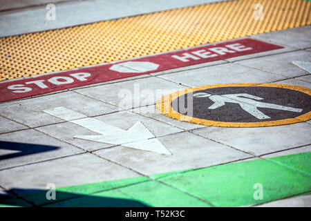 Farbe fahrbahnmarkierungen für Fußgänger an der Kreuzung zur Angabe der Richtung der Bewegung von Fußgängern, von rundem Schild angegeben, und eine sichere Sto Stockfoto