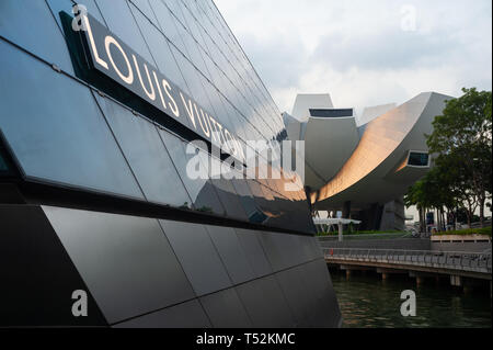 12.04.2019, Singapur, Republik Singapur, Asien - Louis Vuitton Insel Maison luxury Store an der Marina Bay Sands mit ArtScience Museum. Stockfoto