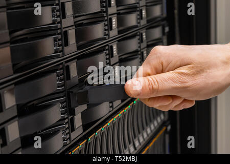 Männliche IT-Techniker ersetzen SAN Server Drive aus dem Rack Stockfoto