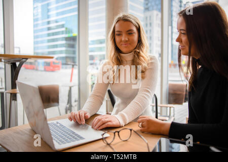 Lächelnd Blogger diskutieren über Laptop am Tisch im Cafe Stockfoto